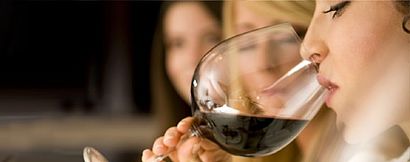 Frau trinkt aus Rotweinglas