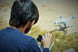 Student von hinten fotografiert mit Drohne am Boden