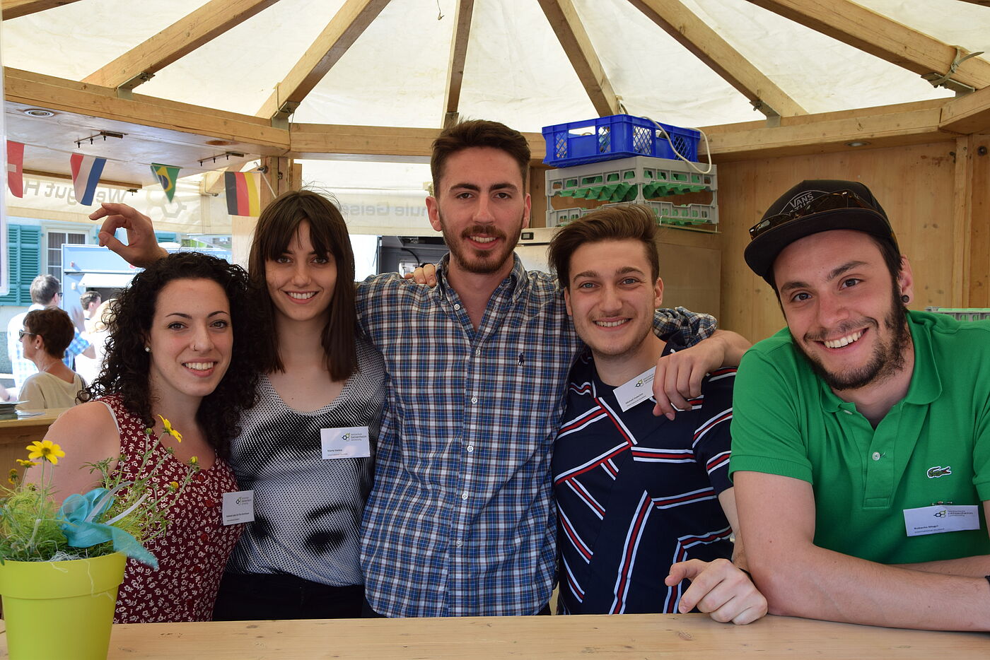 Eine Gruppe italienischer Studierender steht Arm in Arm in einem Weinstand und lächelt in die Kamera. © Hochschule Geisenheim