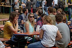 Studenten sitzen auf Bierbänken