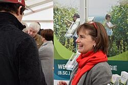 Frau lachend im Vordergrund vom Stand