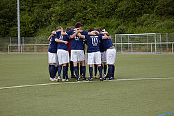Mannschaft der Hochschule steht im Kreis