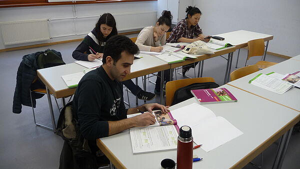 Teilnehmer sitzen an Tischen