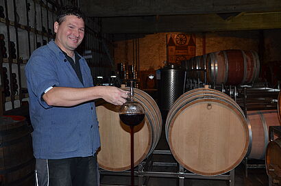 Mann steht vor Weinfässern 