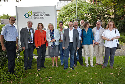 Gruppenbild vor dem Schild der Hochschule