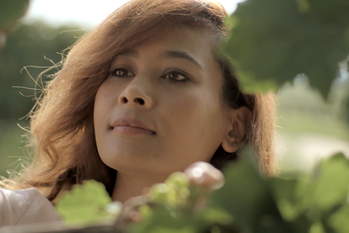 Eine junge Frau steht zwischen Weinreben. © Hochschschule Geisenheim