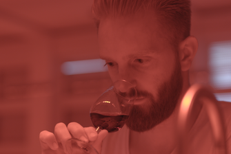 Ein junger Mann beurteilt einen Wein sensorisch. Das Licht im Raum ist rot. © Hochschschule Geisenheim