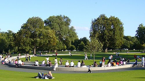 Menschen sitzen auf und neben einem Steinelement in einem grünen Park. © Hochschule Geisenheim
