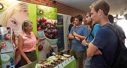 Stand mit Interessenten und Ansprechpartnerin