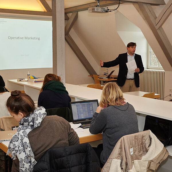 Studierende sitzen in einem kleinen Hörsaal, im Hintergrund ist ein Dozent. © Hochschule Geisenheim / Winfried Schönbach