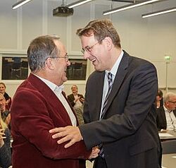 Männer geben sich lachend die Haende