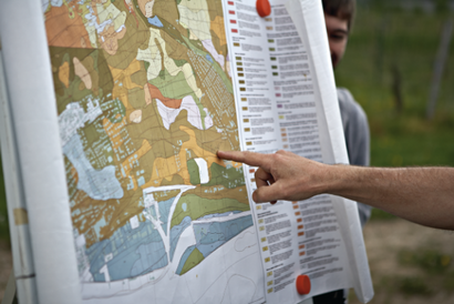 Karte mit verschiedenen Bödenbereichen und zeigender Hand 