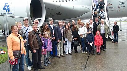 Gruppe steht vor einem Flugzeug