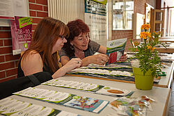 zwei Frauen lesen sich Flyer durch 