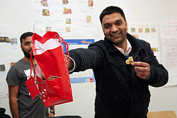 Mann hält lachend Tüte mit Plätzchen