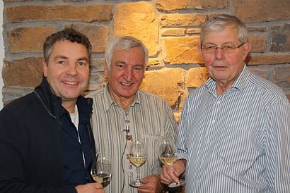 Drei Männer mit Weingläsern in den Haenden 