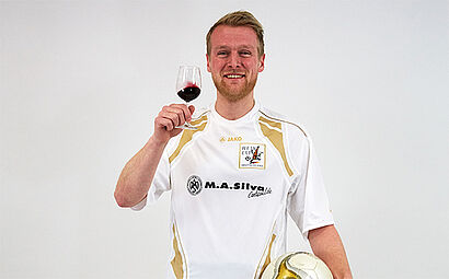 Moritz Volke im Trikot und Weinglas in der Hand