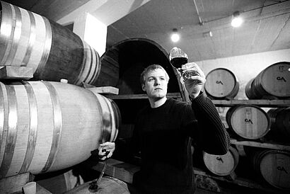 Student Bauer umgeben von Weinfässern