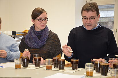 Mann und Frau sitzen vor mit Kaffee gefüllten Gläsern 
