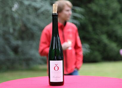 Weinflasche, hinter welcher ein Mann zu sehen ist