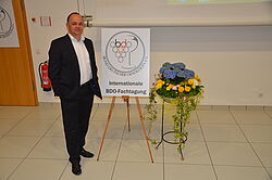 Mann neben BDO Tagungs Schild