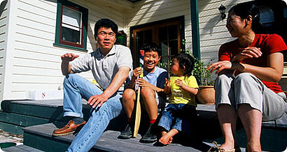 Asiatische Familie sitzt auf der Treppe