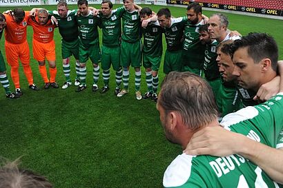 Mannschaft steht im Kreis auf dem Platz