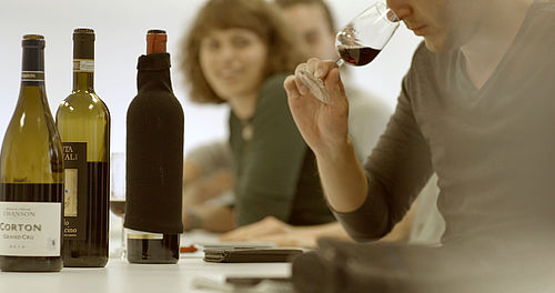 Ein Student riecht an einem Rotwein. Zwei Kommilitonen im Hintergrund schauen zu. © Hochschule Geisenheim