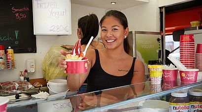 Studentin mit frozen yoghurt im Stand