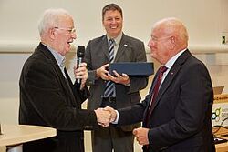 Männer geben sich lachend die Hände