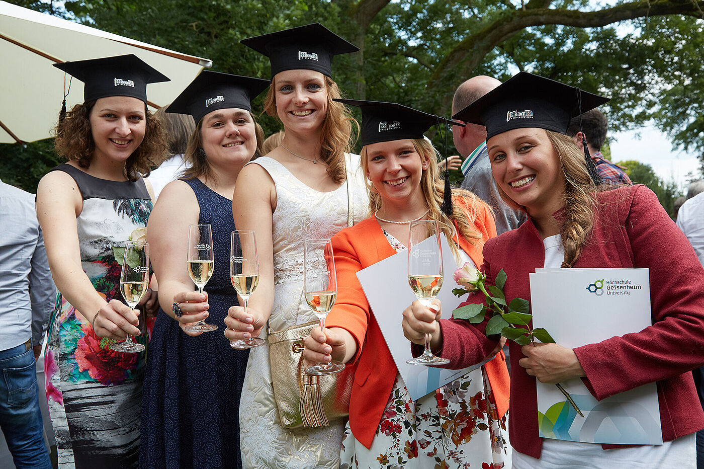 Fünf junge Frauen mit Absolventenhüten und Urkunden stoßen an. © Hochschule Geisenheim / Winfried Schönbach