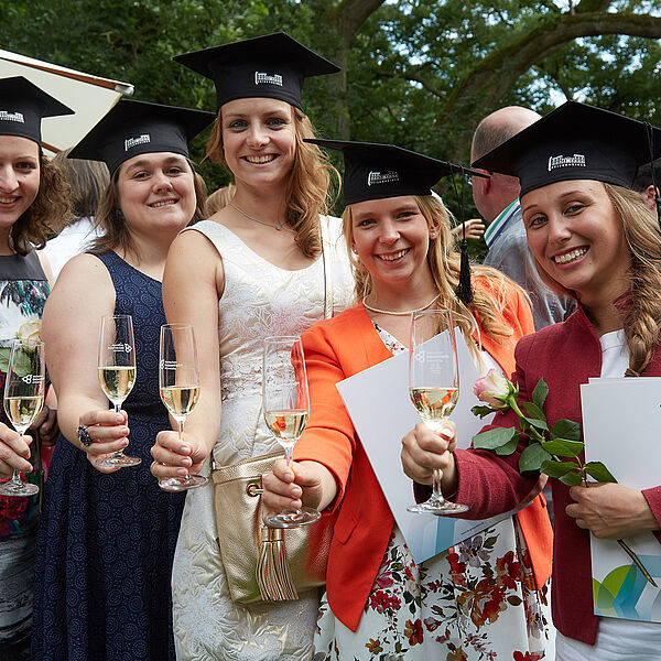 Fünf junge Frauen mit Absolventenhüten und Urkunden stoßen an. © Hochschule Geisenheim / Winfried Schönbach