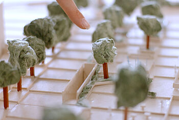 Ein Finger deutet auf Details eines Modells mit Plätzen, Treppen und Bäumen. © Hochschule Geisenheim