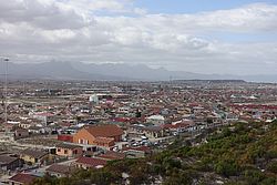 Blick über Khayelitsha. Im Hintergrund eine Bergkette vor Gordons Bay und die Südatlantikküste (Falls Bay)