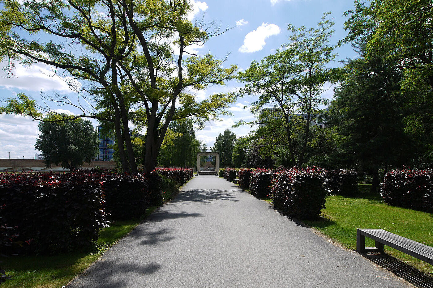 Eine Parkanlage mit einem Torbogen über einen Kiesweg. © Hochschule Geisenheim