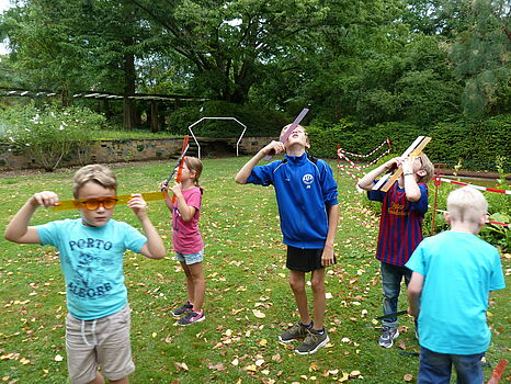 [Translate to English:] Kinder schauen durch verschiedenfarbene Platikscheiben