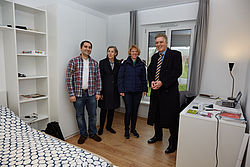 Vier Personen stehen in einem voll ausgestatteten Zimmer in einem Studierendenwohnheim. © Hochschule Geisenheim / Winfried Schönbach
