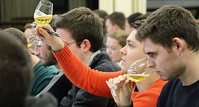 Studenten mit Bierglas in der Hand, welches hoch gehalten wird