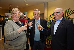 drei Personen stossen an 