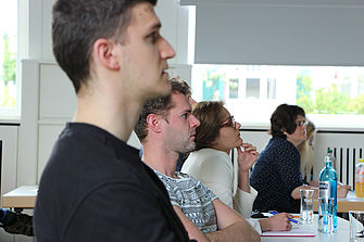 Mehrere junge Menschen sitzen an Tischreihen und schauen gespannt nach vorne. © Hochschule Geisenheim
