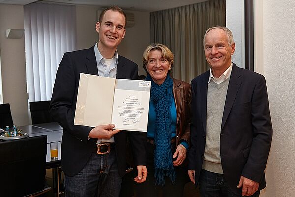 Mann,Frau und Student mit Preis in den Händen zu sehen 