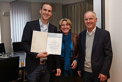 Mann,Frau und Student mit Preis in den Händen zu sehen 