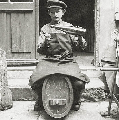 schwarz-weiss Aufnahme von einem Jungen mit Weinflasche