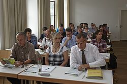 Teilnehmer sitzen an Tischen