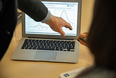 Ein Dozent deutet auf eine Kurve in einer Präsentation auf dem Laptop © Filmagentur Rheingau