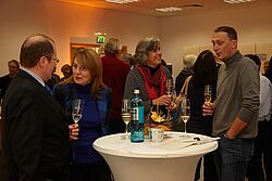 Gruppe um Stehtisch herum stehend