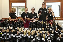 Team vor Weinflaschen