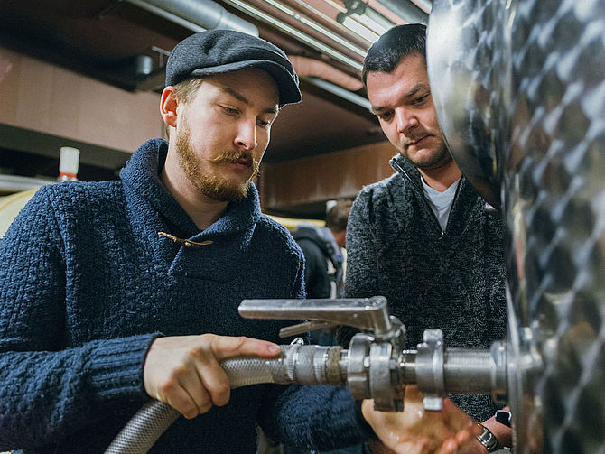Zwei junge arbeiten an einem Stahlfass. © Hochschule Geisenheim / Steffen Boettcher