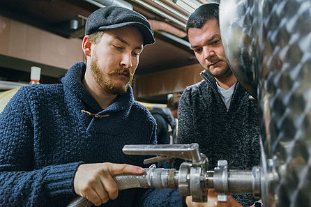Zwei junge arbeiten an einem Stahlfass. © Hochschule Geisenheim / Steffen Boettcher