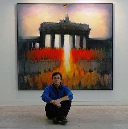 Kunstler sitzt vor seinem Gemälde 